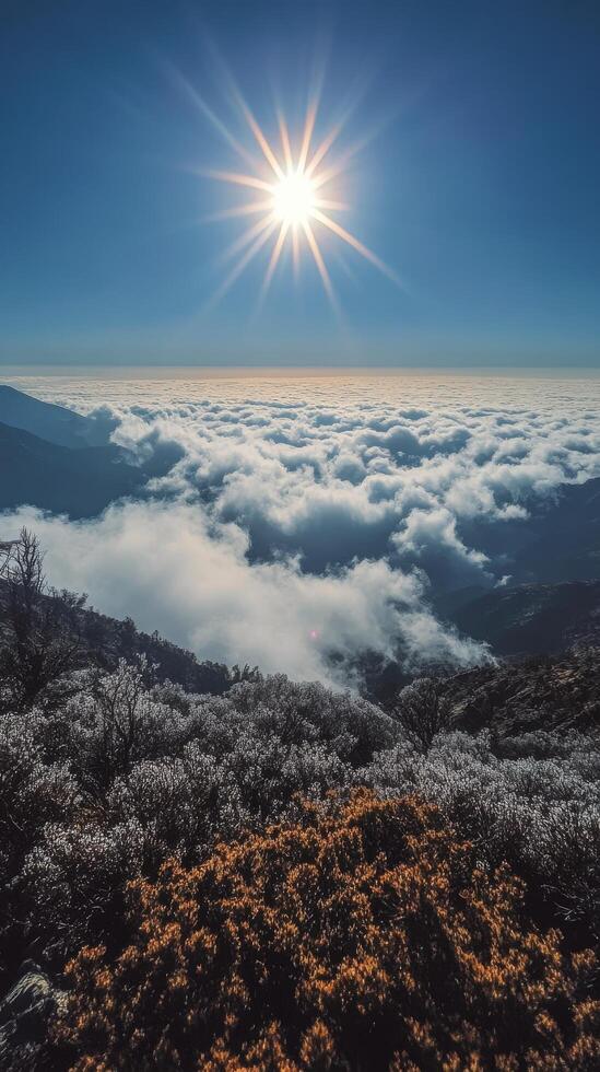 The sun shines over the clouds and mountains in this photo