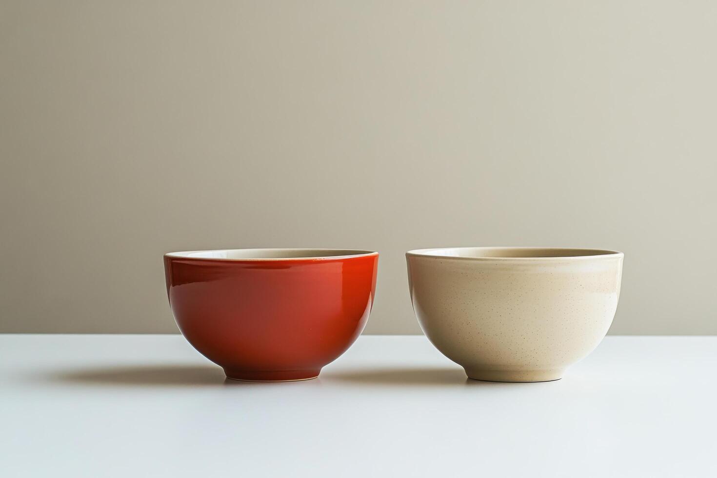 Two red and one beige bowls sitting on a table photo