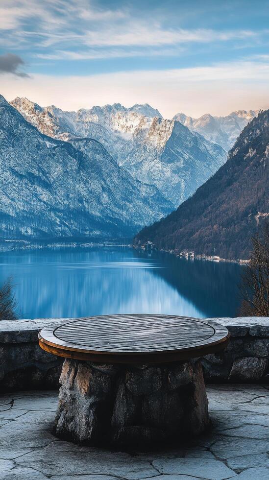 A stone table sitting in front of a lake and mountains photo