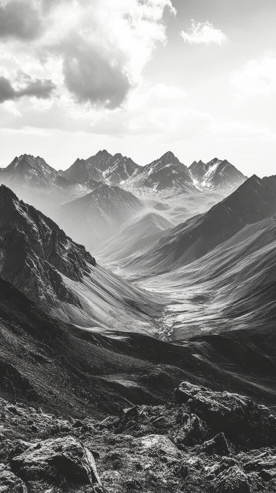 Majestic mountain range with rugged peaks and deep valleys during misty daylight photo