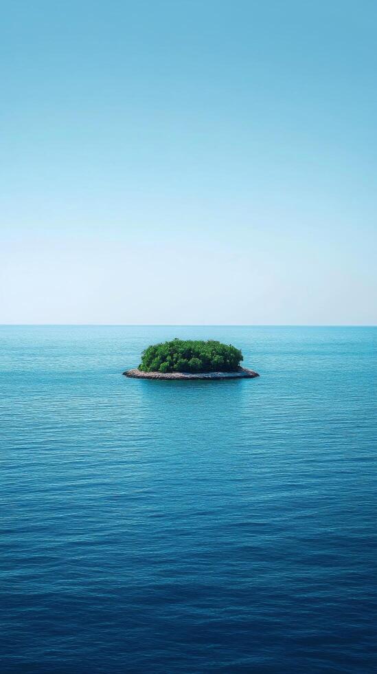 Lush green island surrounded by calm blue ocean under a bright sky with scattered clouds photo