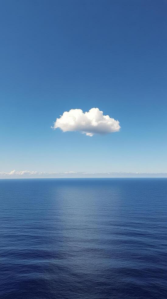 A lone cloud floating in the middle of the ocean photo