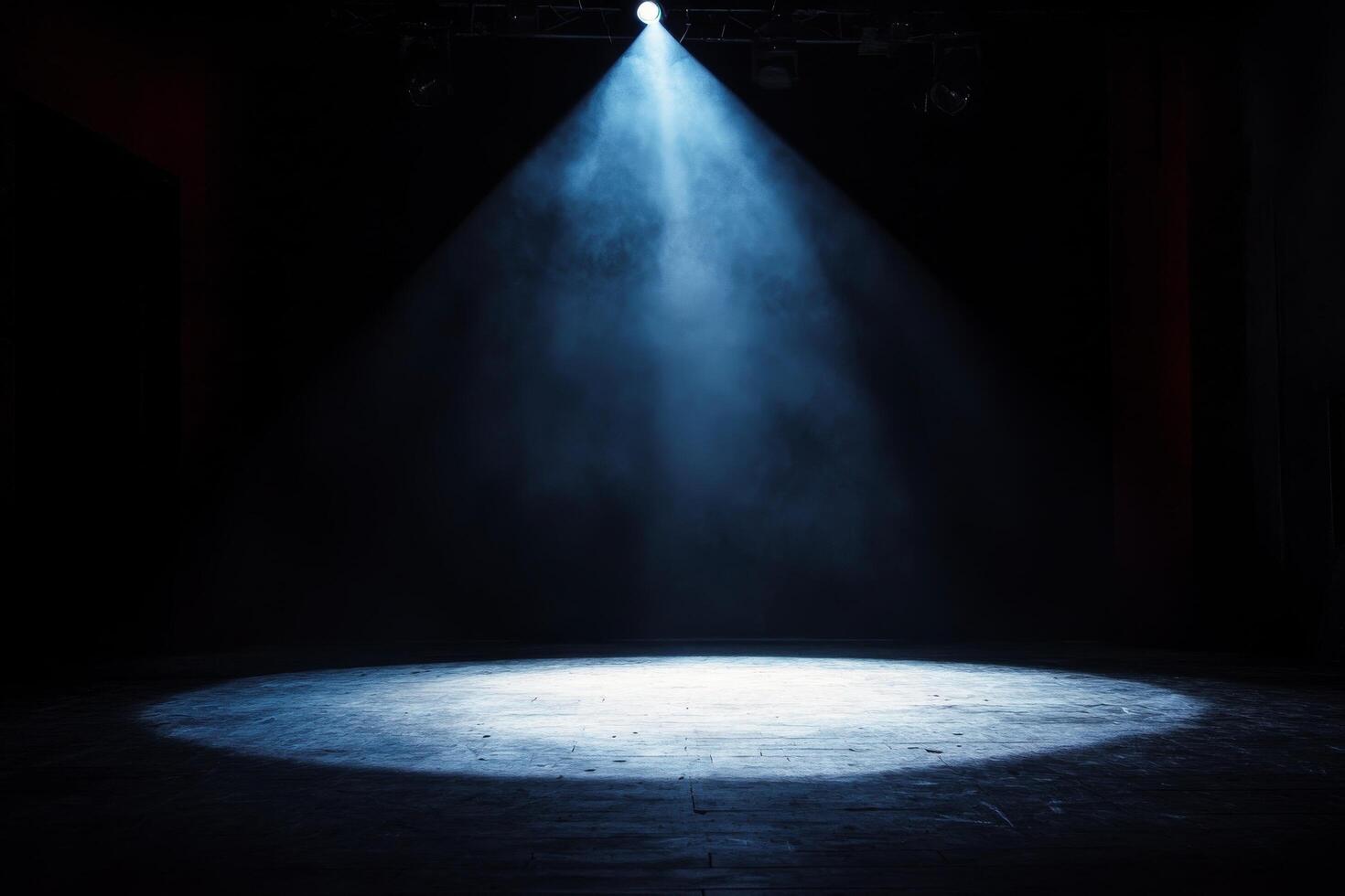 A spotlight shines on a stage with smoke photo