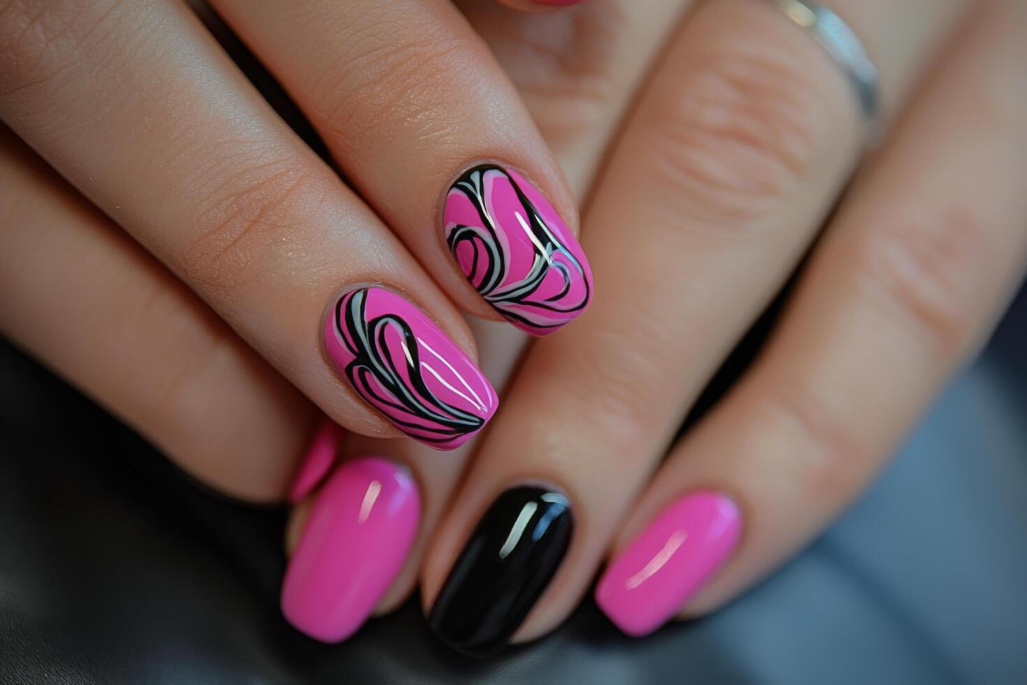 A woman's hand with pink and black nail designs photo