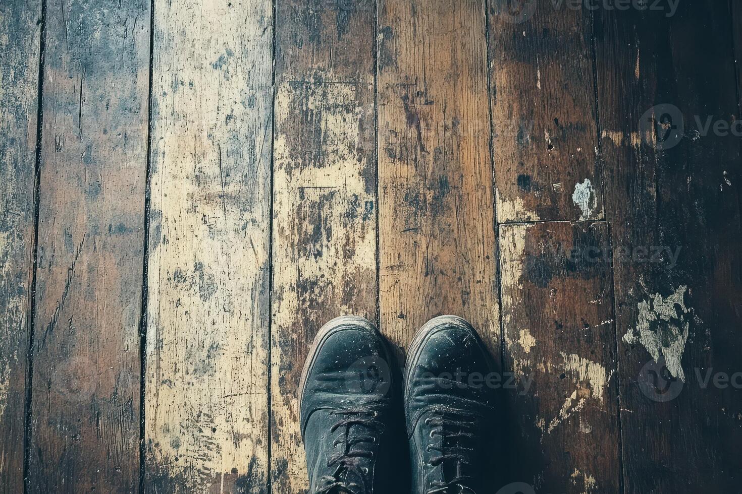 Dusty shoes stand on distressed and worn hardwood flooring photo