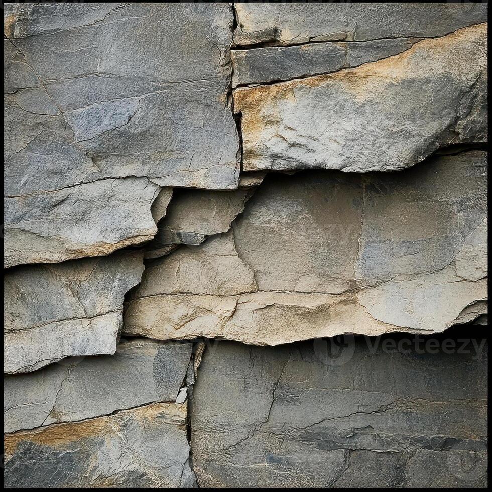 Gray and tan stone wall with layered and textured surfaces photo
