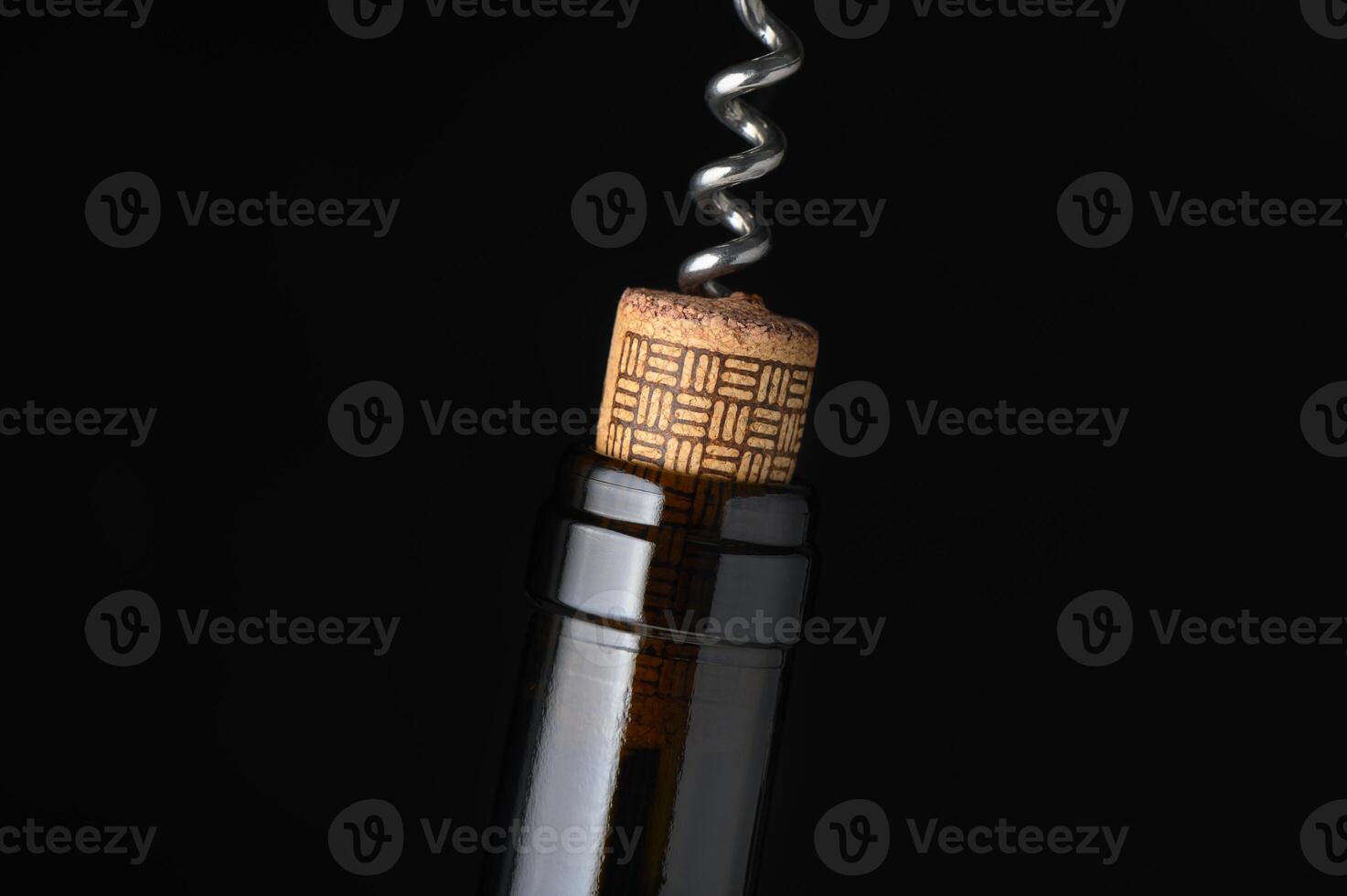 Wine bottle and corkscrew captured in elegant detail against a dark background photo