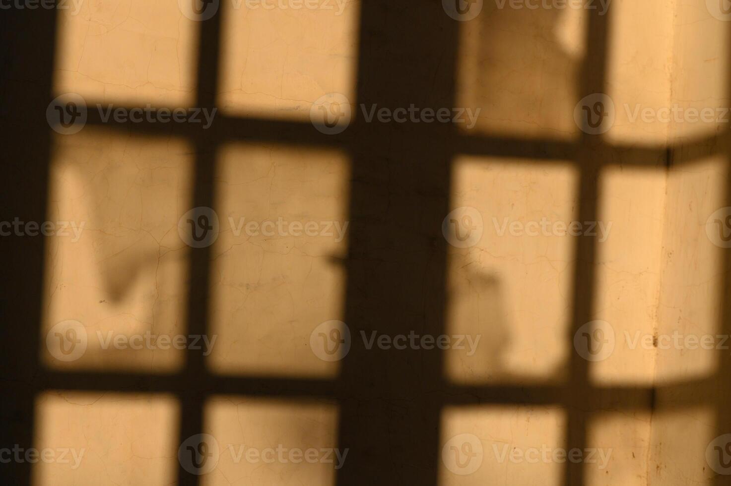 Shadows play on the walls of an old building during a warm afternoon sun photo
