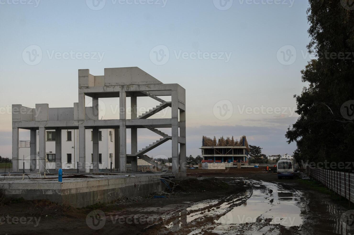 Construction site at dusk showcasing modern architecture and ongoing development in an urban area photo