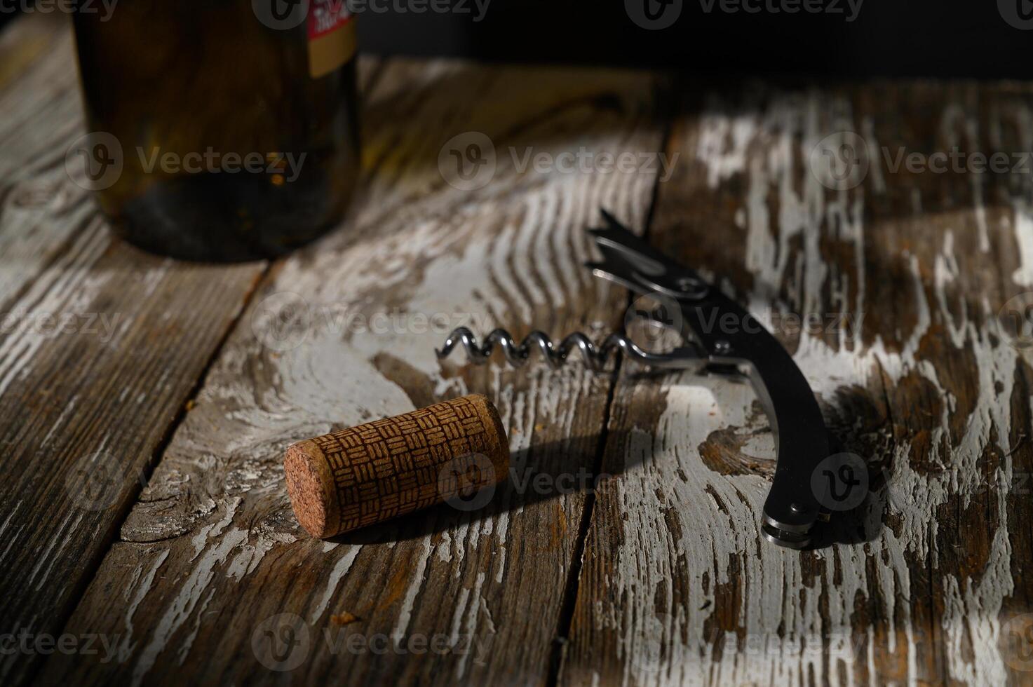 Enjoying an evening of fine wine with a corkscrew and bottle on a rustic wooden table photo