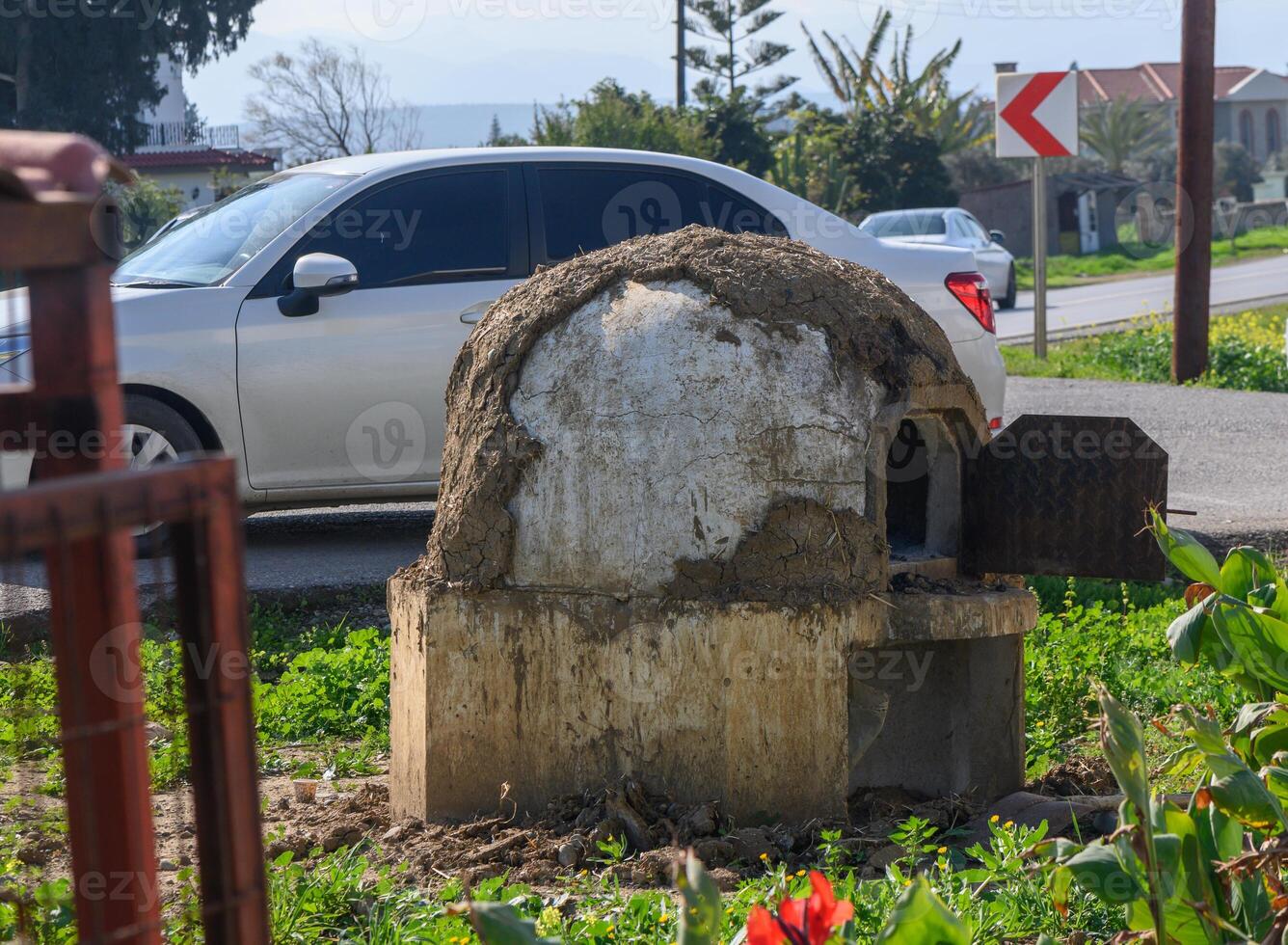 Unique rustic oven stands proud beside a quiet road under the warm sun photo