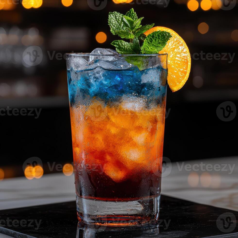 Colorful cocktail with ice, orange slice, and mint garnish photo