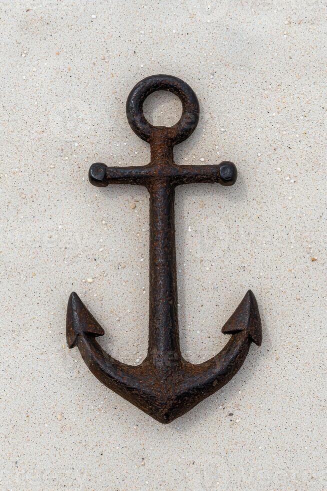Rusty anchor on a sandy surface photo