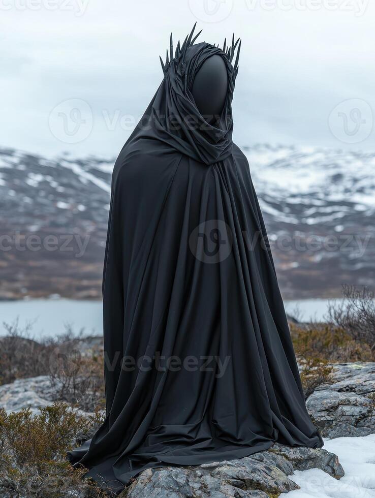 A mysterious figure in black robes stands in a desolate landscape photo