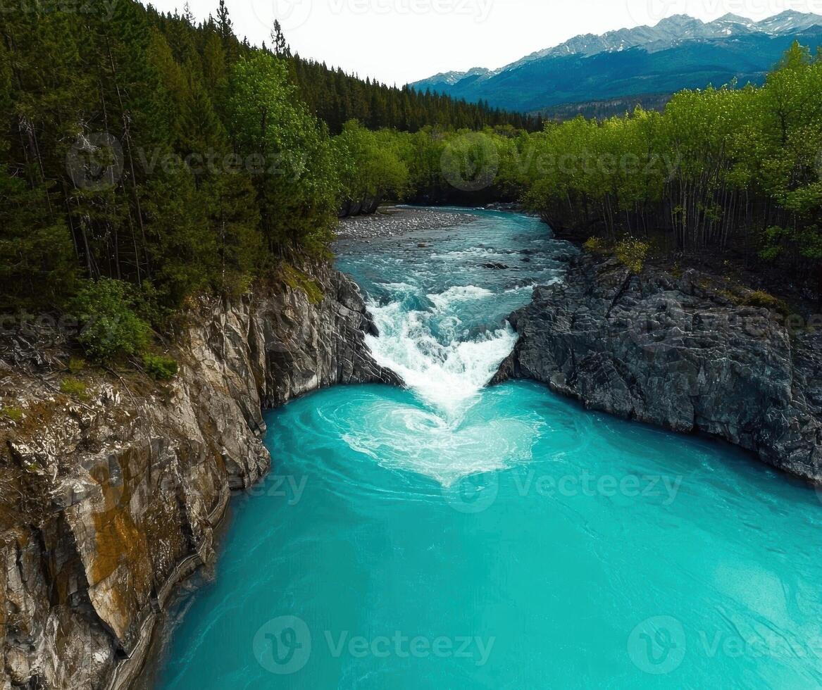 Turquoise river flowing through a rocky landscape with mountains in the background photo