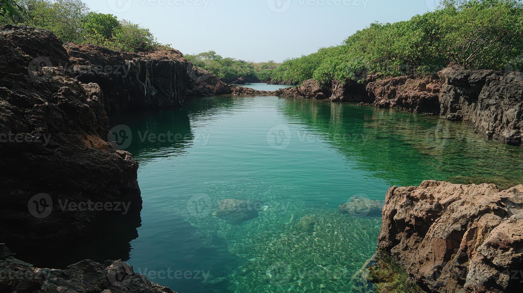 Tranquil turquoise waters surrounded by rocky cliffs and lush greenery photo
