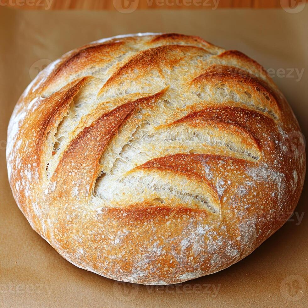 A loaf of freshly baked sourdough bread on parchment paper photo