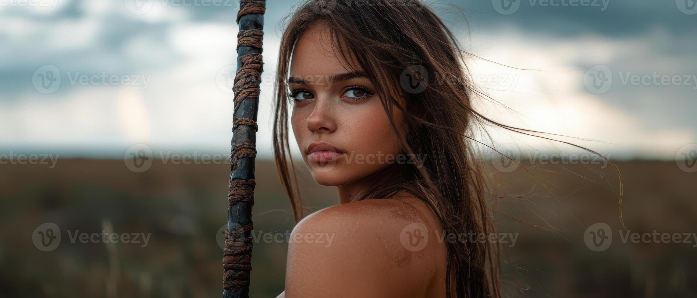 A young woman with a rustic staff in a natural setting photo