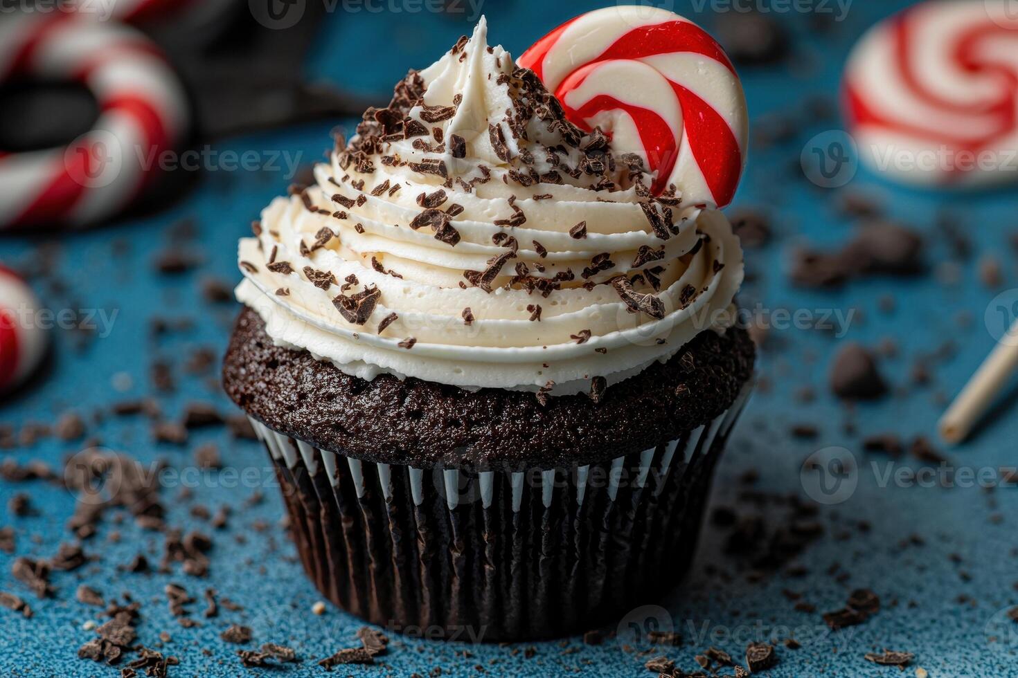A festive chocolate cupcake with white frosting and a candy cane photo