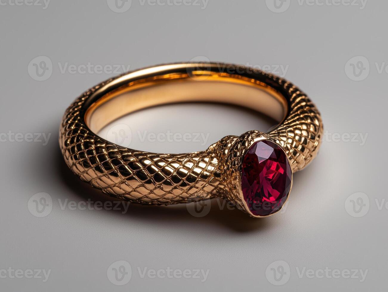 A gold snake ring with a red ruby gemstone photo