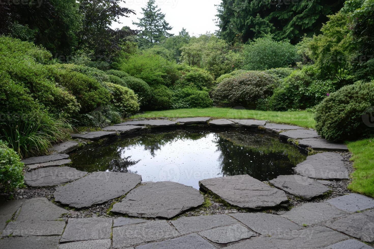 A tranquil pond surrounded by lush greenery and stone paving photo