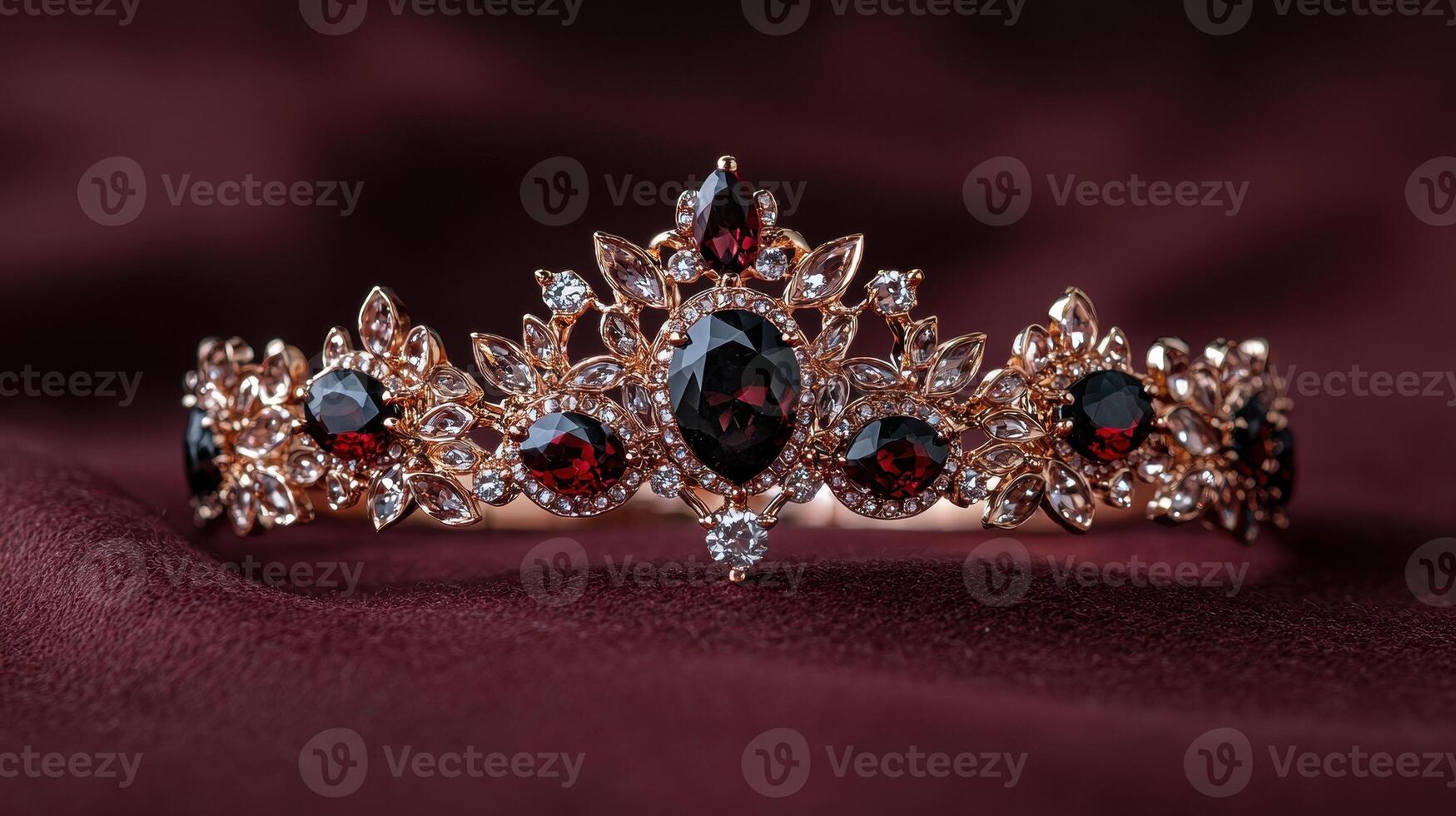 Elegant tiara with red and clear gemstones on a burgundy fabric photo