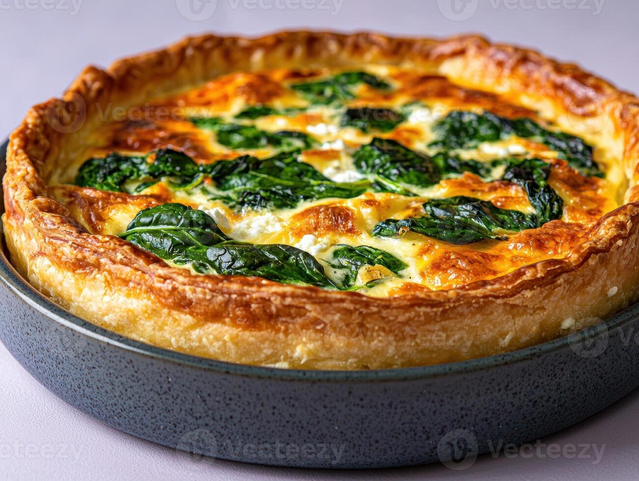 A delicious spinach and feta quiche in a ceramic dish photo