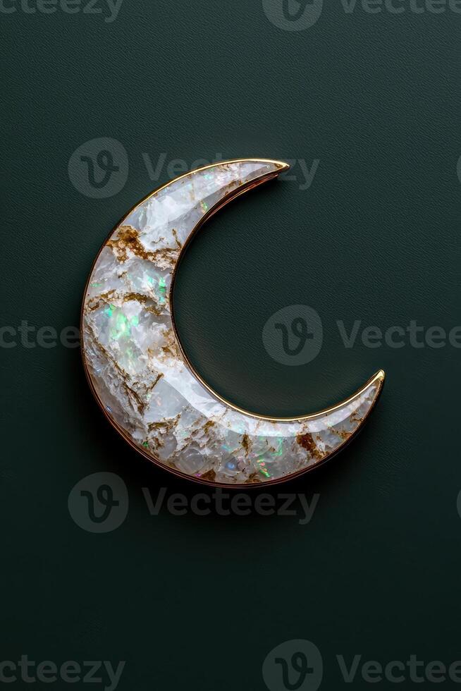 Crescent moon pendant with opal inlay against a dark green background photo
