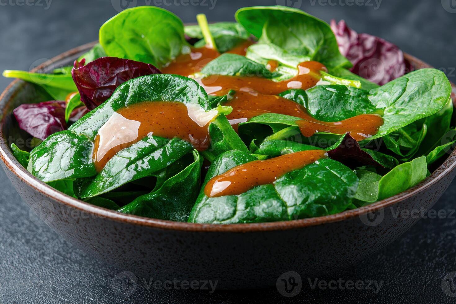 Fresh spinach salad with vinaigrette dressing in a bowl photo