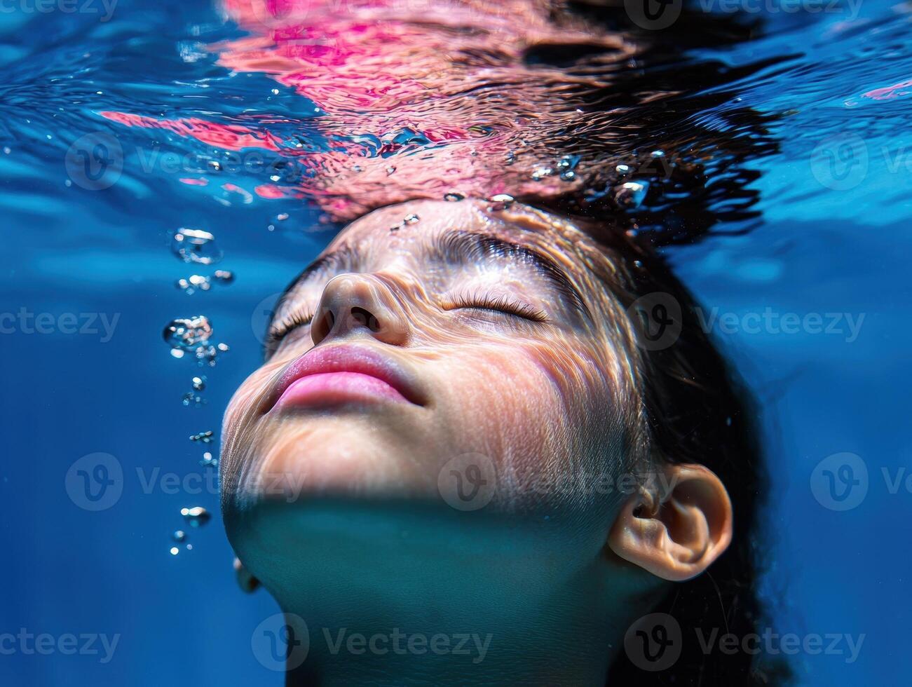 Girl submerged underwater with eyes closed photo