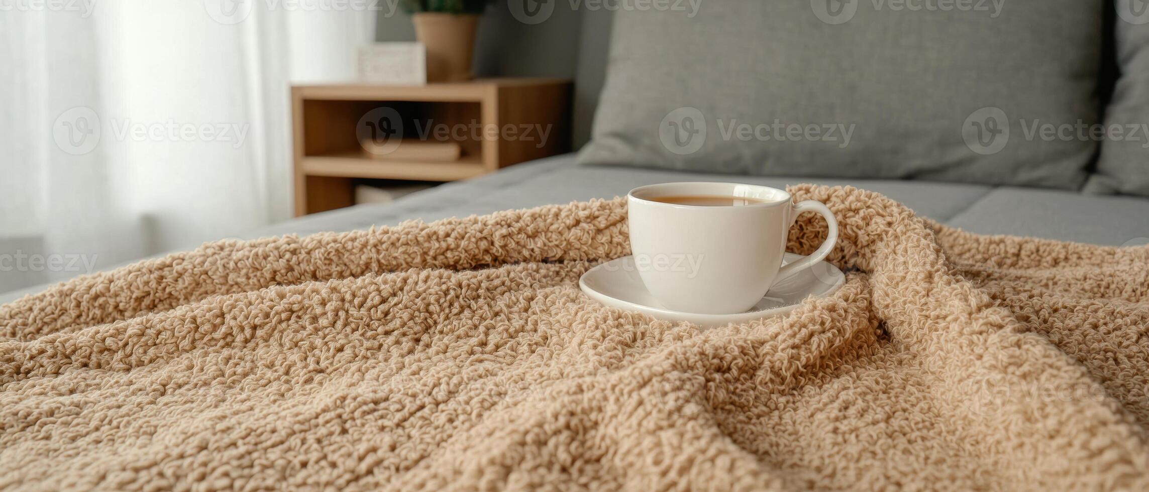 A cozy morning with a cup of tea on a soft blanket photo