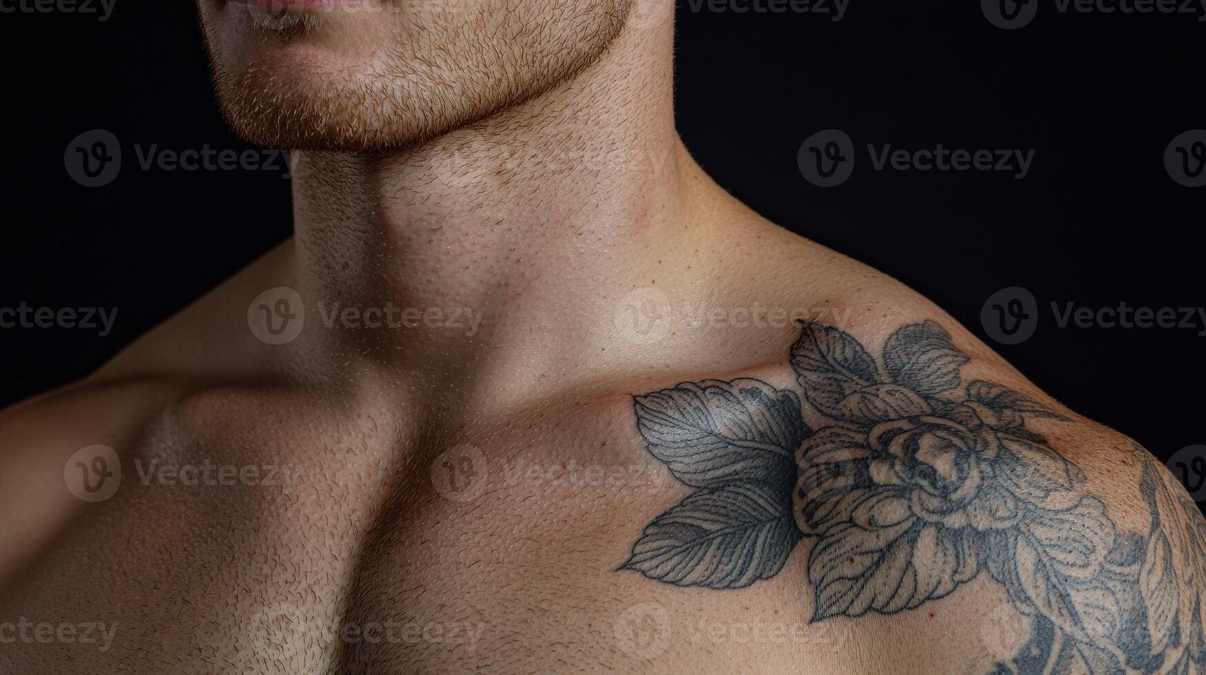 Close up of a mans chest and shoulder with a floral tattoo photo