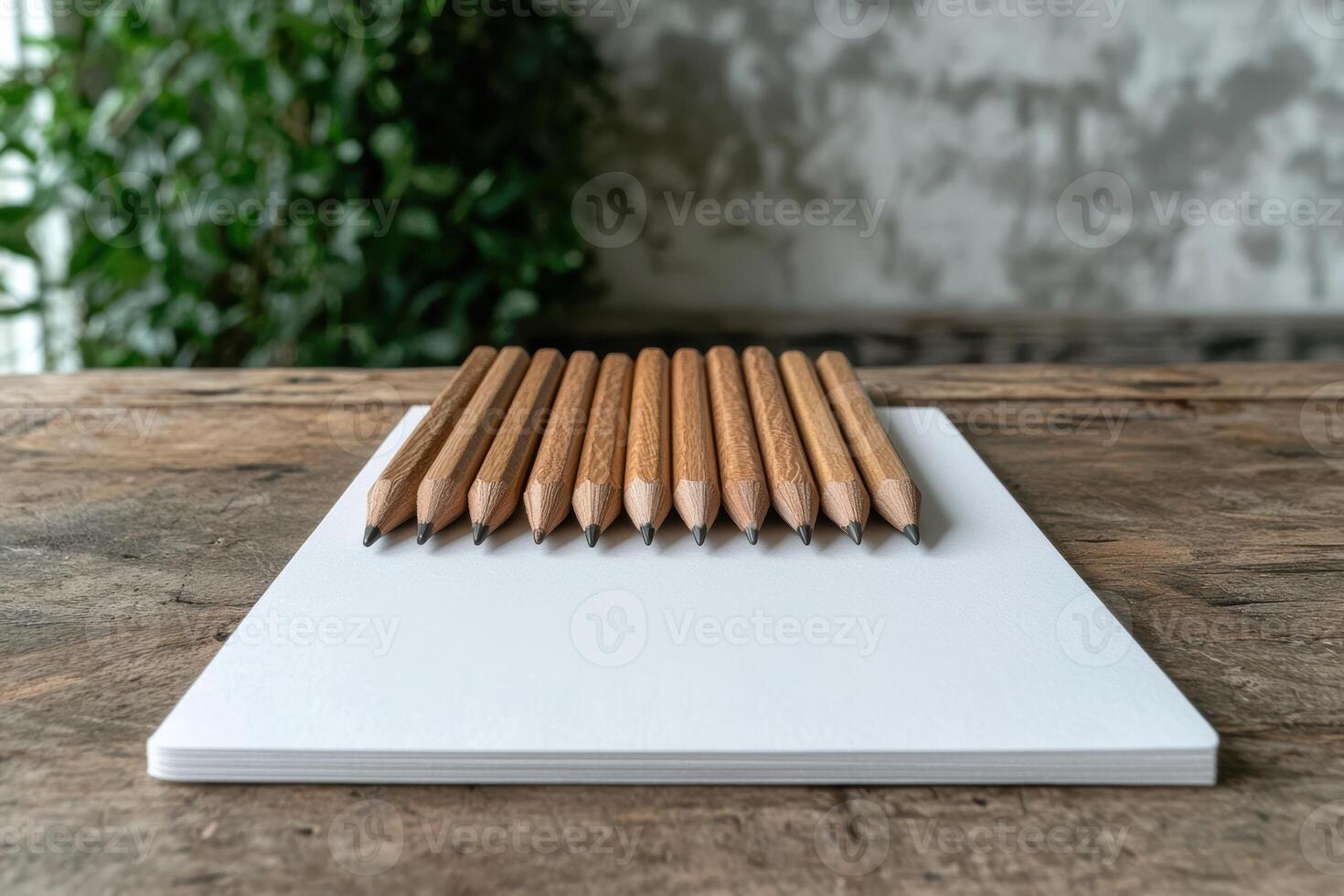 Wooden pencils on a blank notepad on a wooden table photo