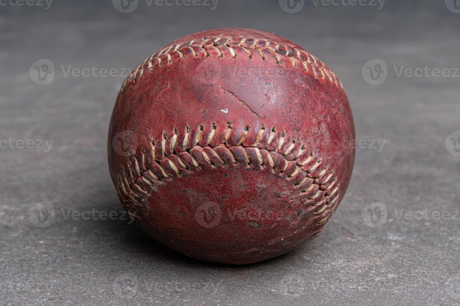 An old, worn baseball with visible stitching photo