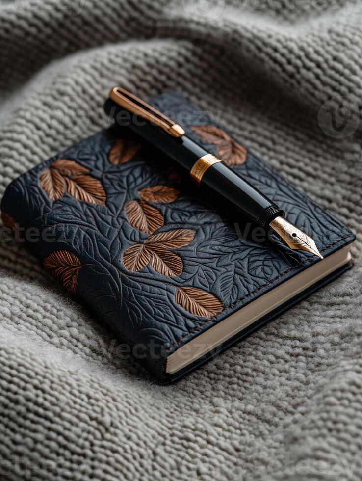 Elegant fountain pen resting on a leather bound journal with leaf design photo