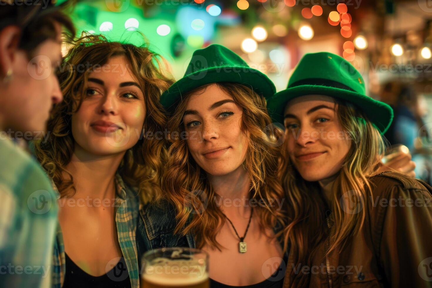 Three women are smiling and wearing green hats. One of them is holding a glass of beer. Scene is cheerful and festive. St. Patrick's Day beer bar on national holiday. Drinking party. photo