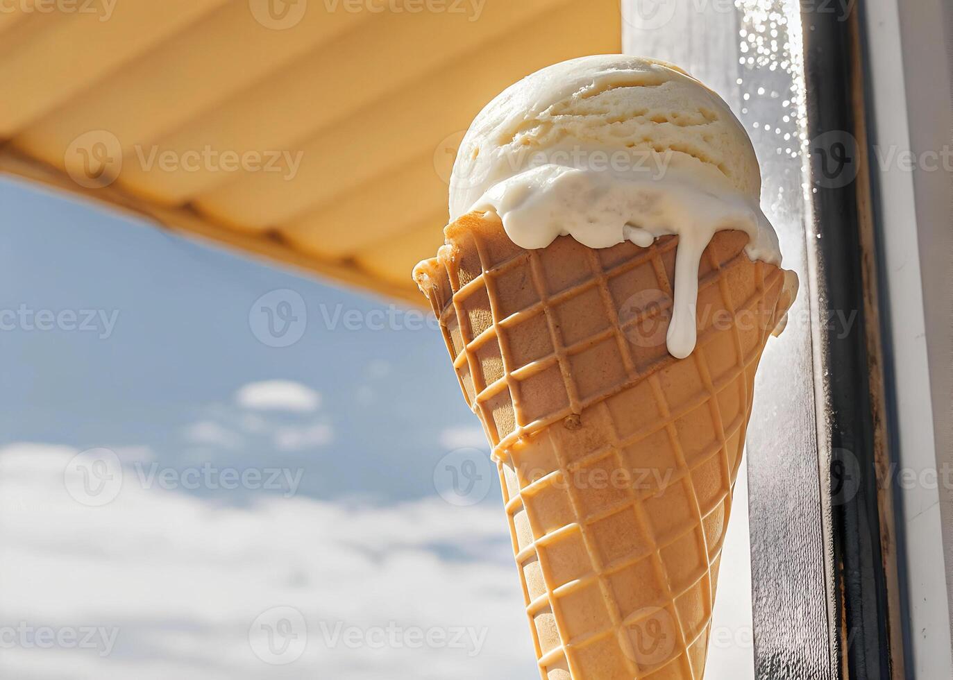 Ice cream cone with a creamy, set against a clear blue sky with a few clouds photo