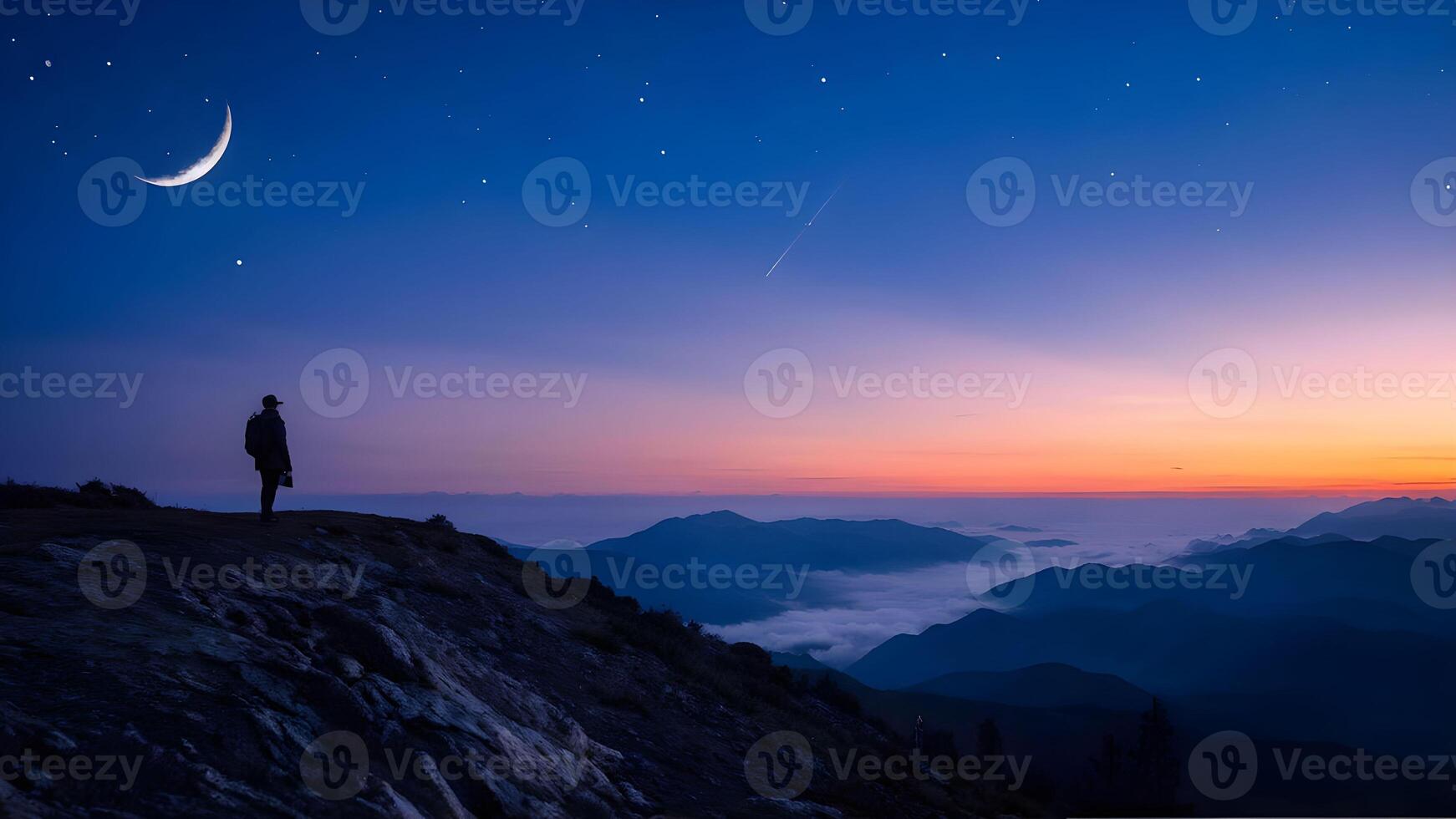 a sunrise in a mountainous area. The sky is a beautiful blend of purple and orange hues, and the silhouette of the mountains in the background creates a serene and majestic atmosphere. photo