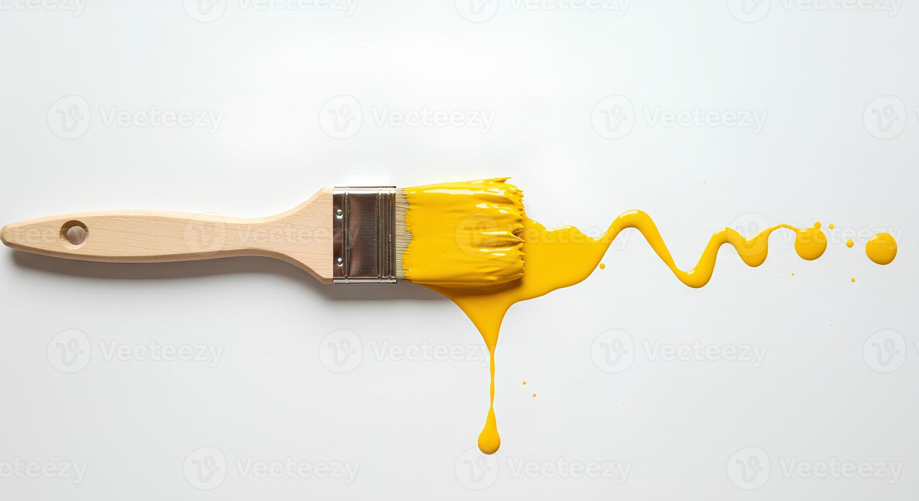 Paintbrush and yellow paint splatter isolated on white background Dynamic image of a paintbrush with bold yellow paint splatters on a white background great for art-related branding photo