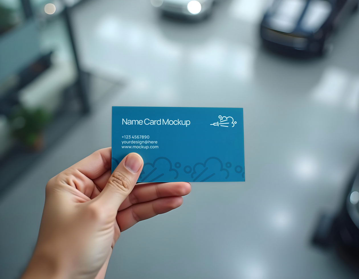 A hand holds a blue name card mockup in a showroom psd