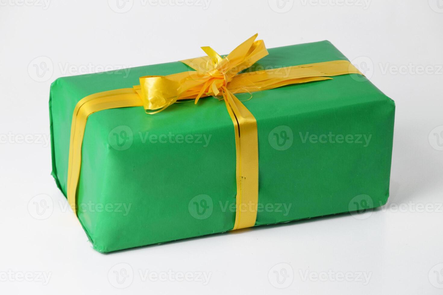 Green Gift Box Featuring a Golden Ribbon Against a White Background photo