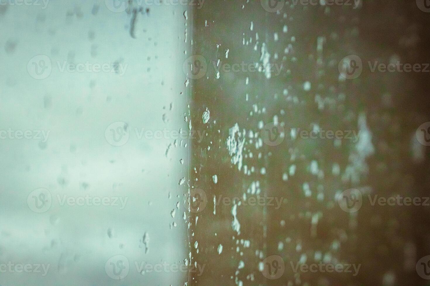 Drops on glass on rainy cloudy day evoke melancholy and sadness. View of city from the window. Selective focus. High quality photo