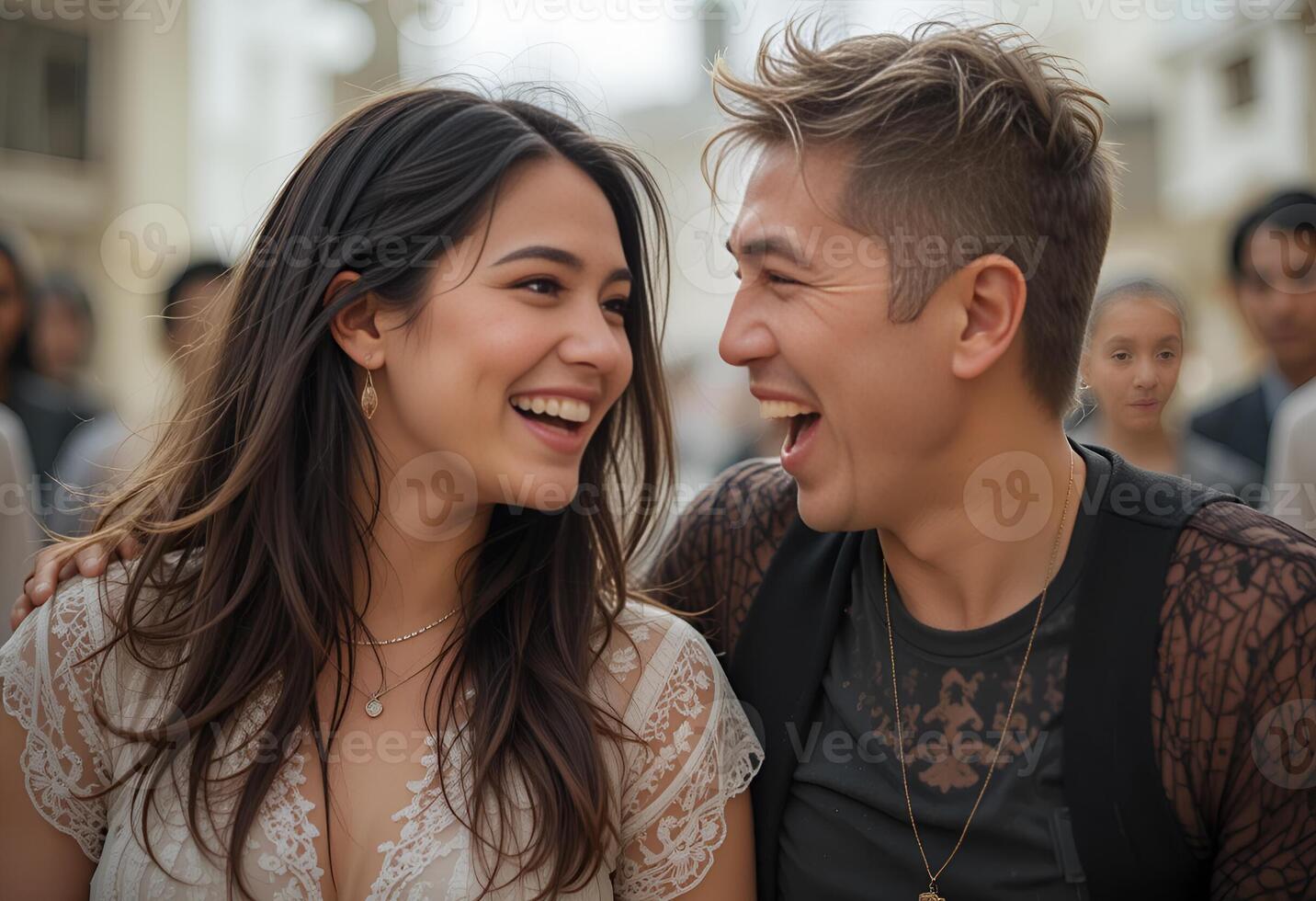 A man and a woman who are laughing and looking at each other. They are outside, . The girl is wearing a white dress with lace, and the man is wearing a black T-shirt with a lace cape. photo