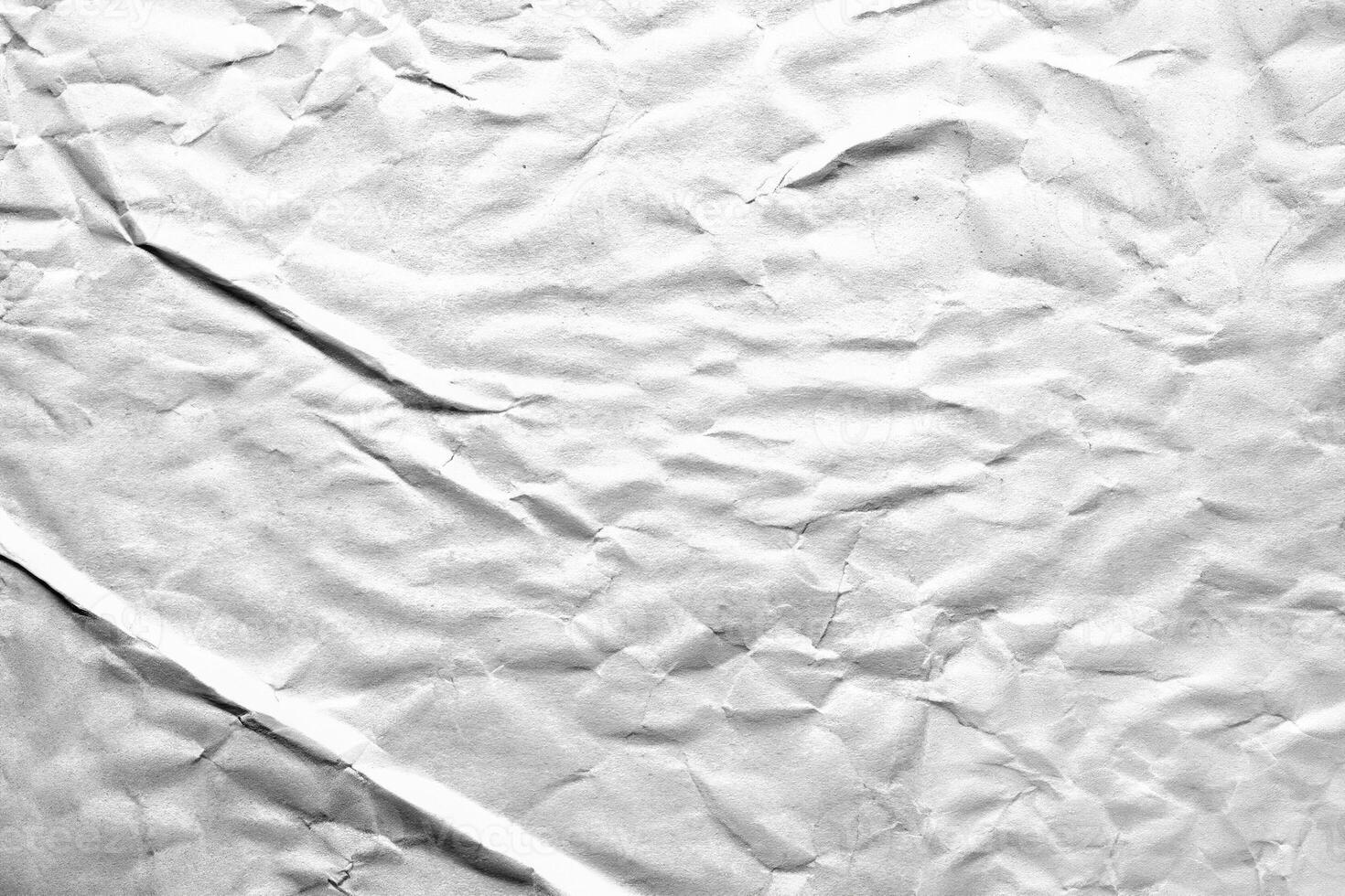 Crumpled white paper texture with detailed folds and wrinkles, ideal for backgrounds or overlay effects. photo