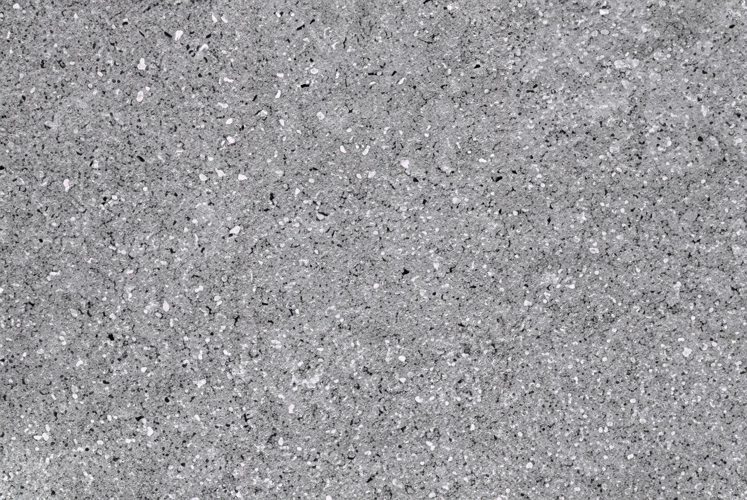 Close-up of a grey speckled stone texture, showcasing natural patterns and rough surface details. photo
