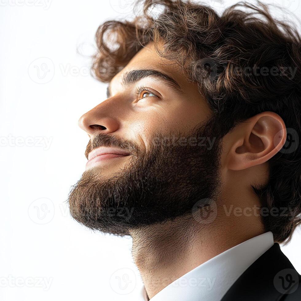 Young man with curly hair smiles while looking up, showcasing confidence in bright indoor lighting photo