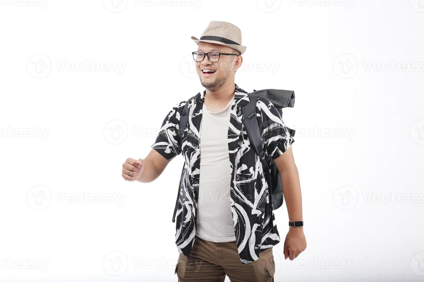 Happy young Asian man wearing a straw hat and backpack doing a walking or strolling gesture. photo