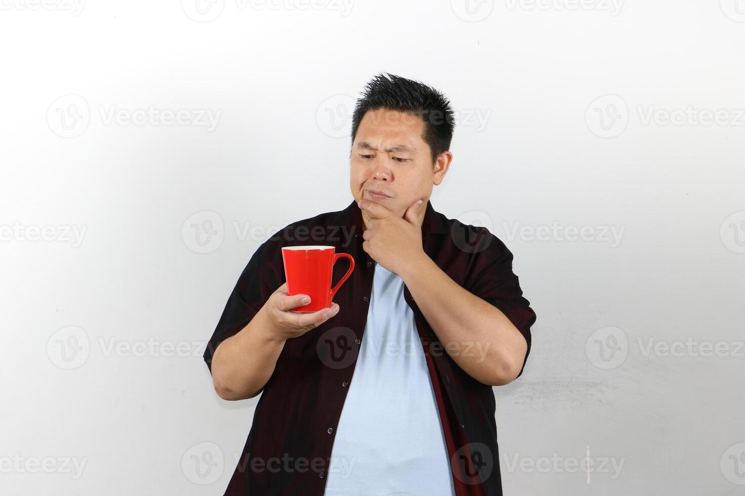 Man showing Thinking expression while holding a Red Mug photo