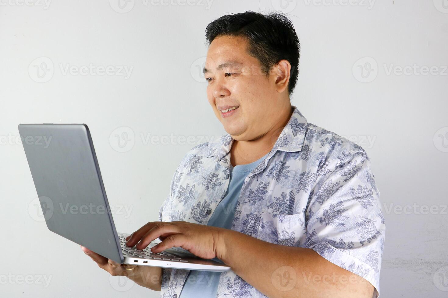 Smiling Man Working on Laptop over isolated white background photo