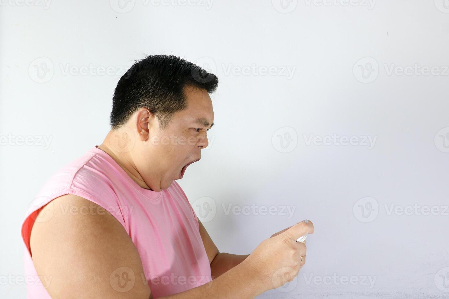 Angry Man with open mouth Looking at His Phone photo